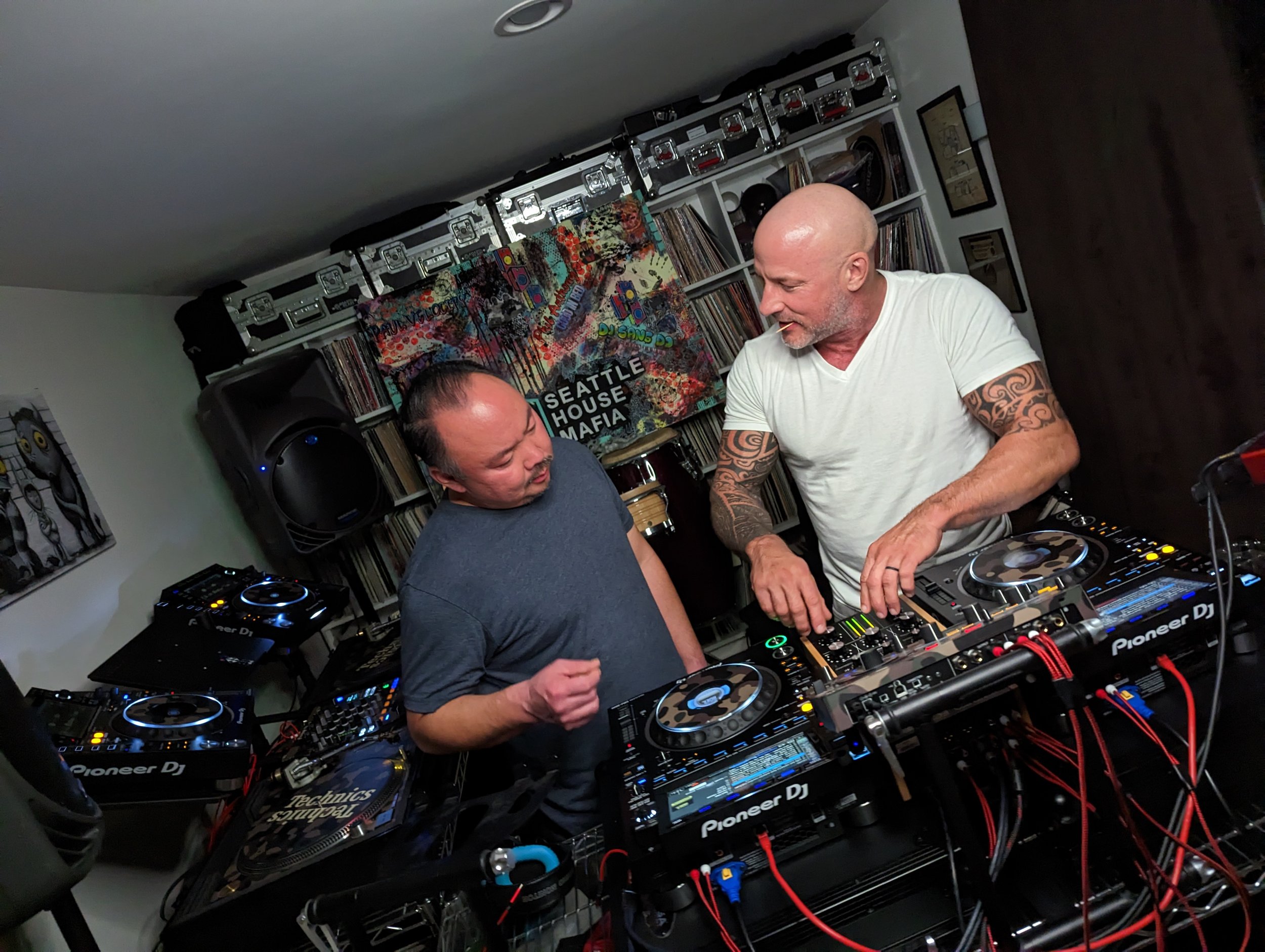 DJ smiling at camera while streaming, with mobile phone setup showing live feed