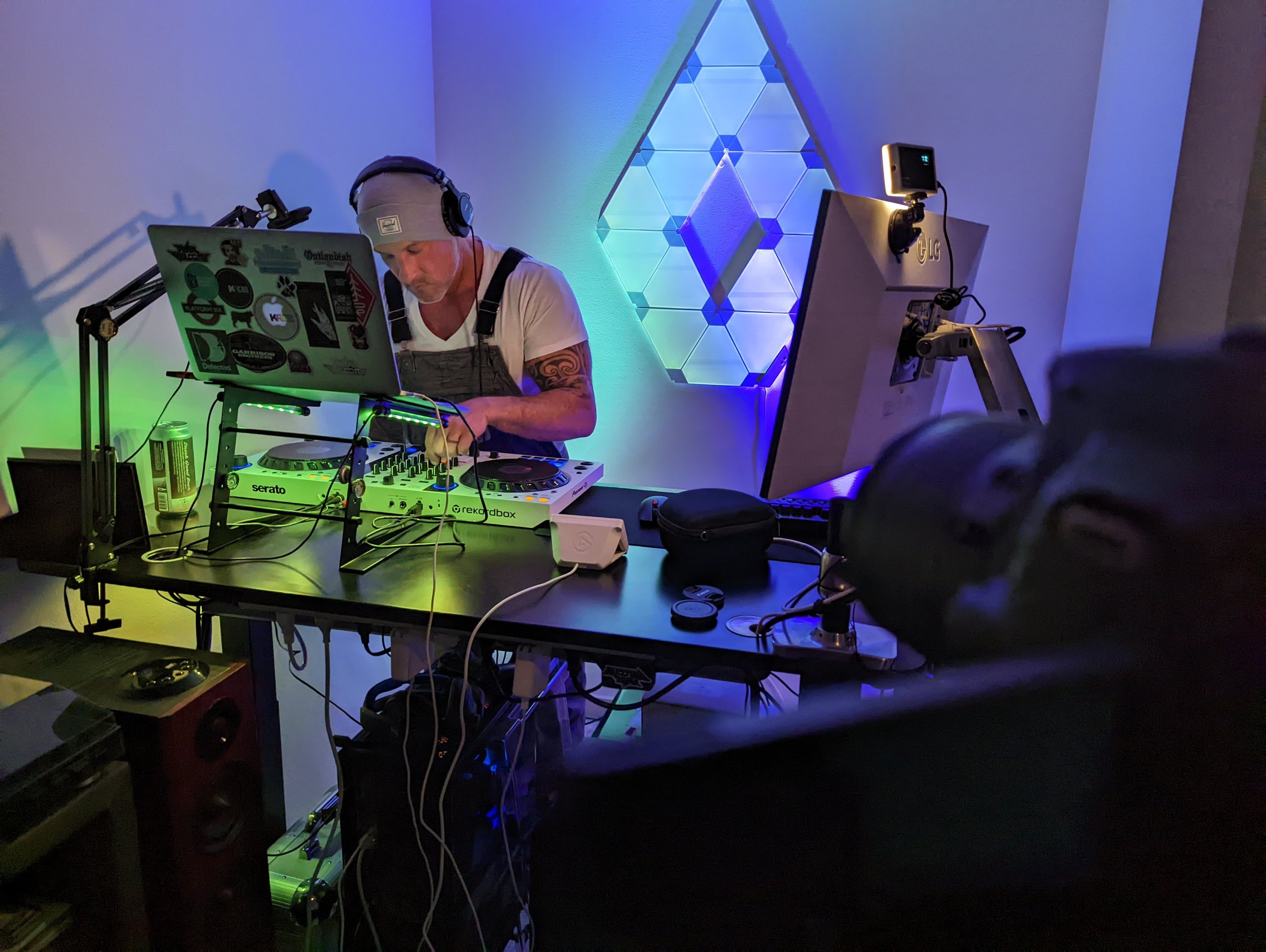 Nightclub scene with DJ performing and crowd dancing under colored lighting