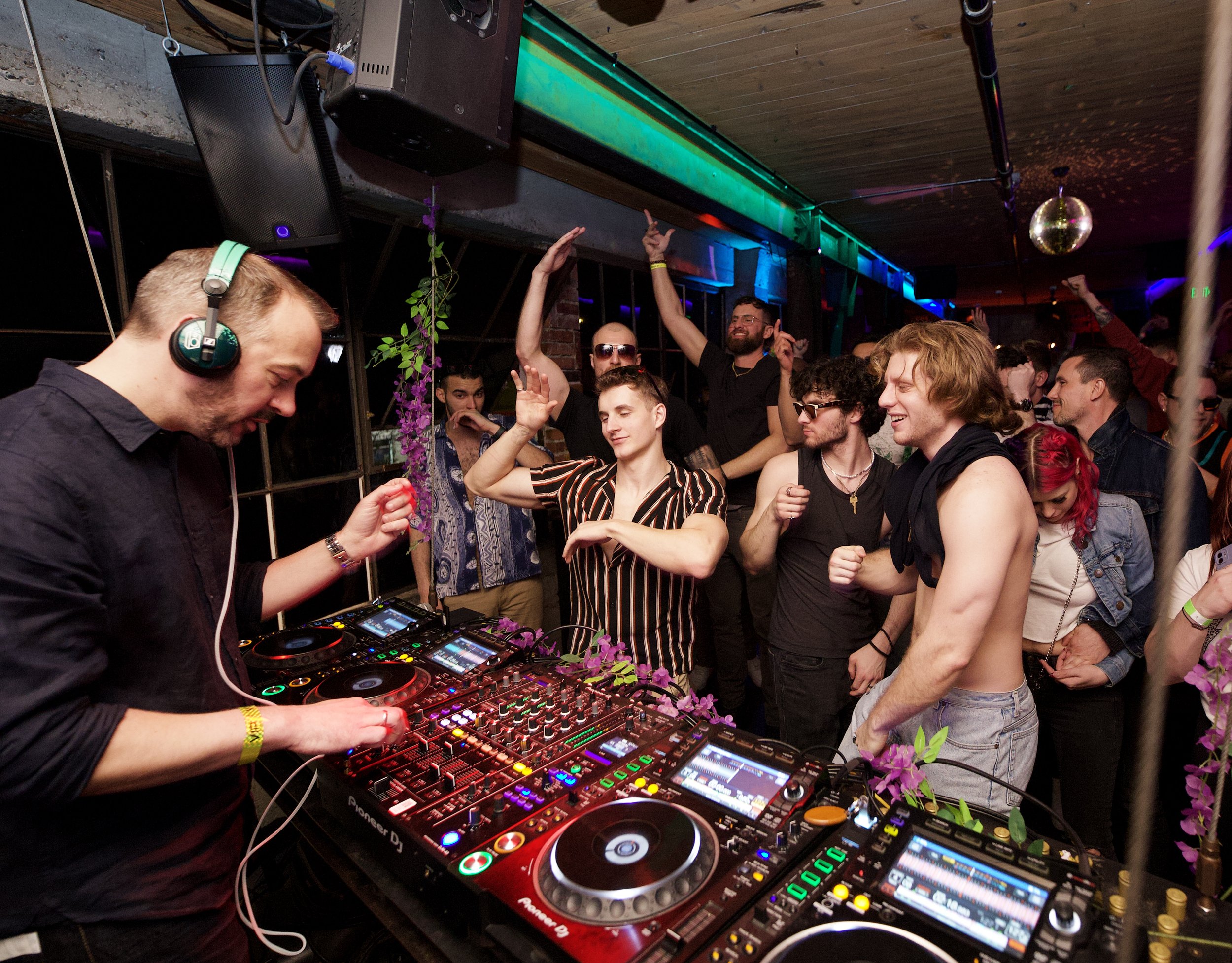 DJ performing on a rooftop with scenic Seattle waterfront view at sunset