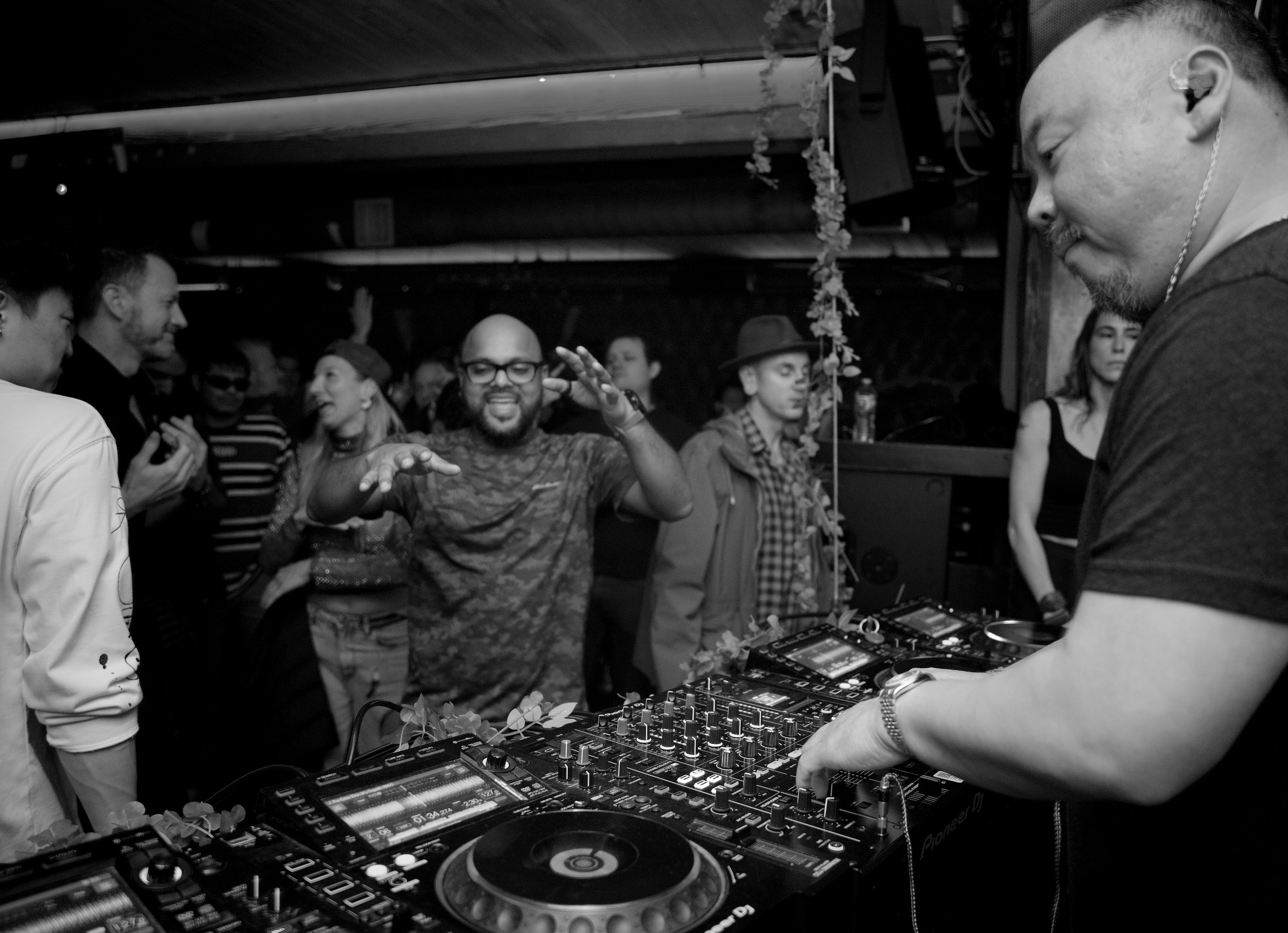 DJ equipment setup with Pioneer CDJs and mixer under atmospheric blue and red lighting