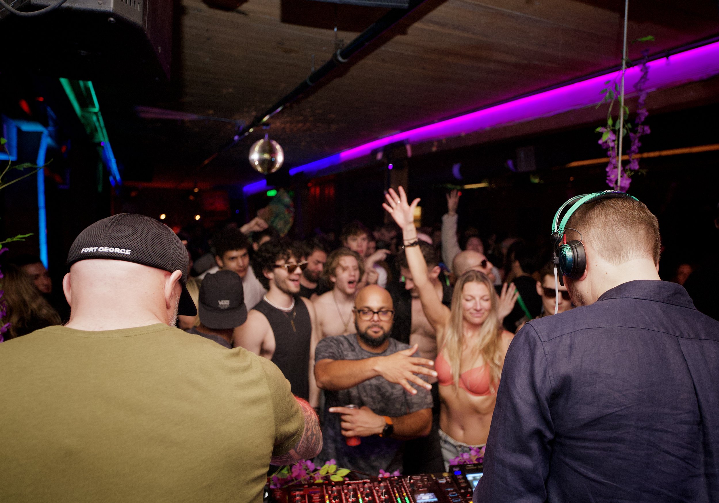 Seattle House Mafia DJs walking together on a brick-lined street carrying equipment cases