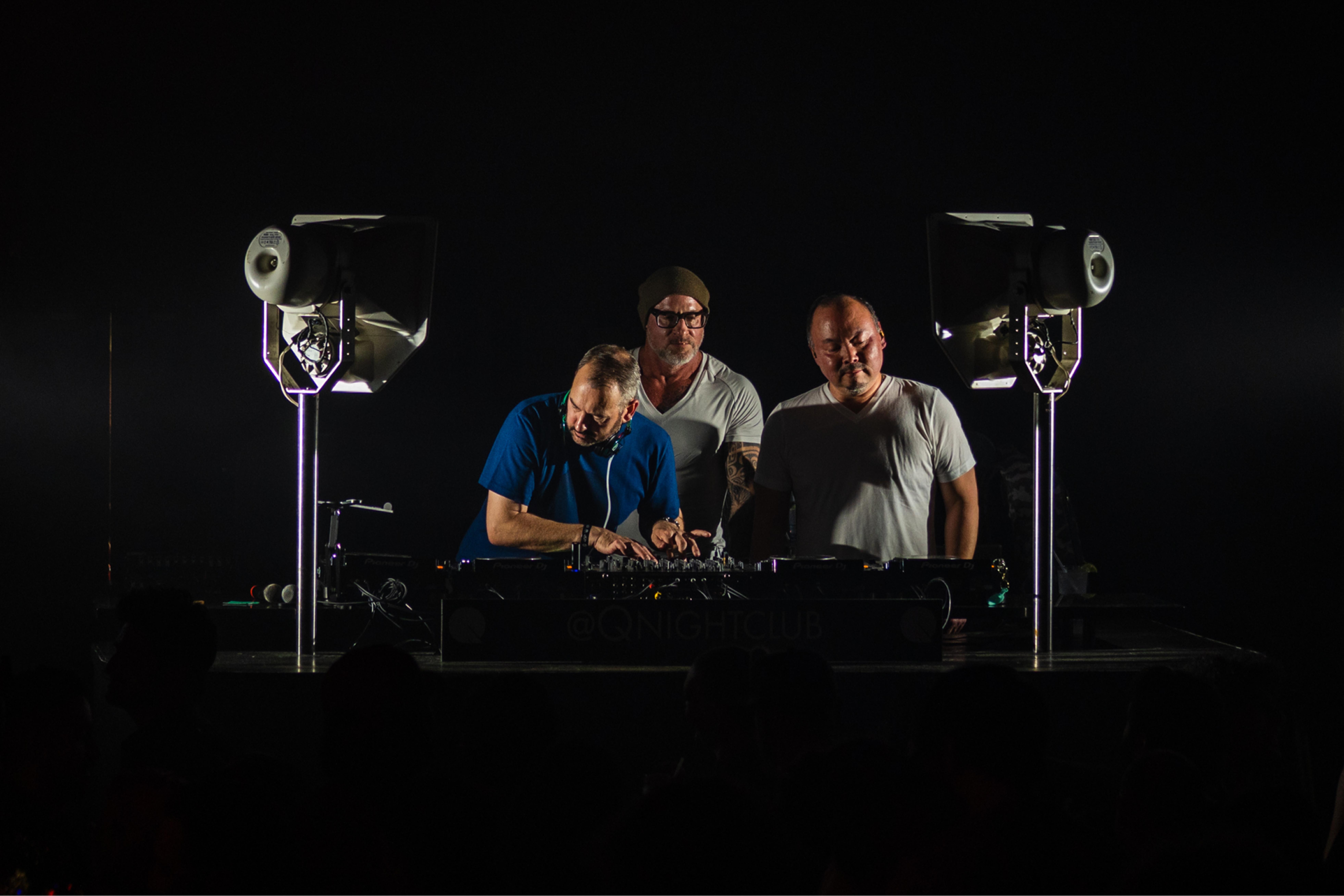 The Seattle House Mafia trio performing together on a darkened stage at Q Nightclub