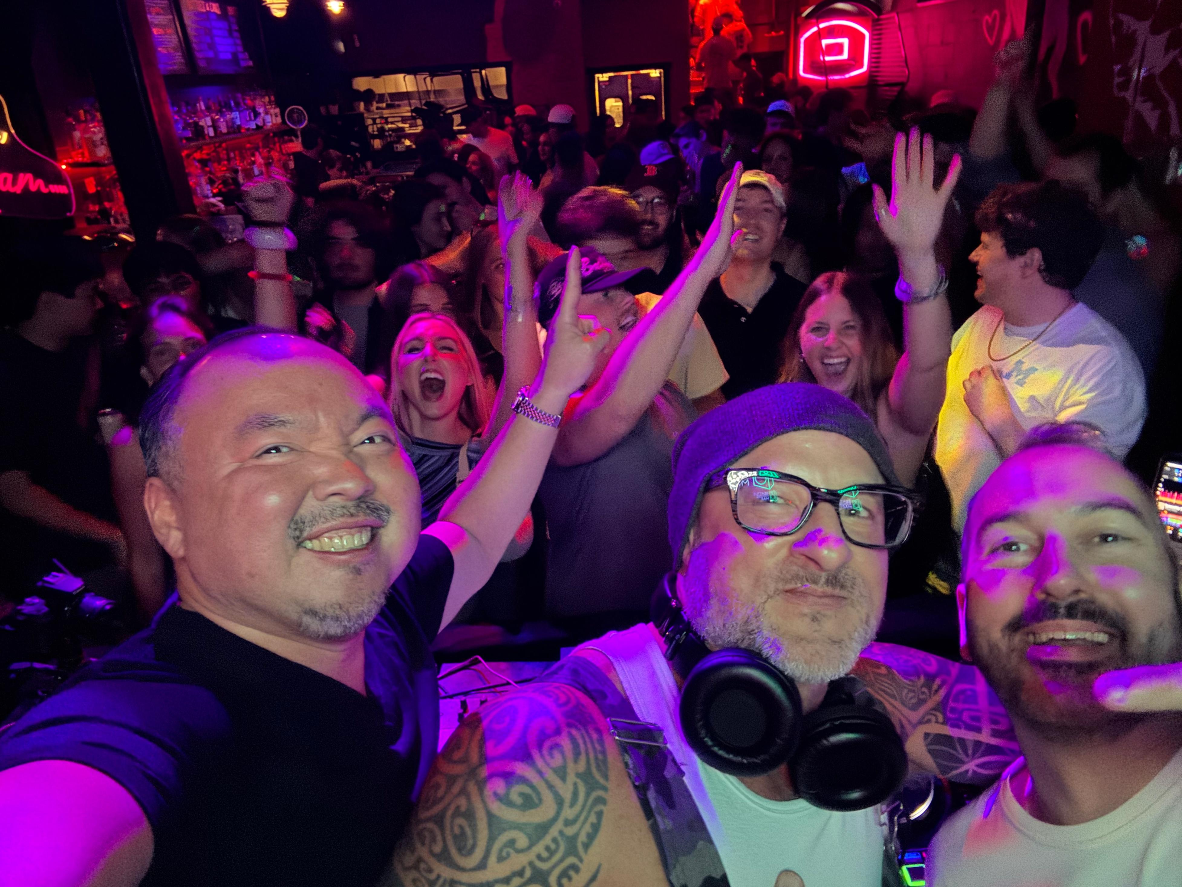 Seattle House Mafia in the booth with the crowd cheering and hands in the air behind them