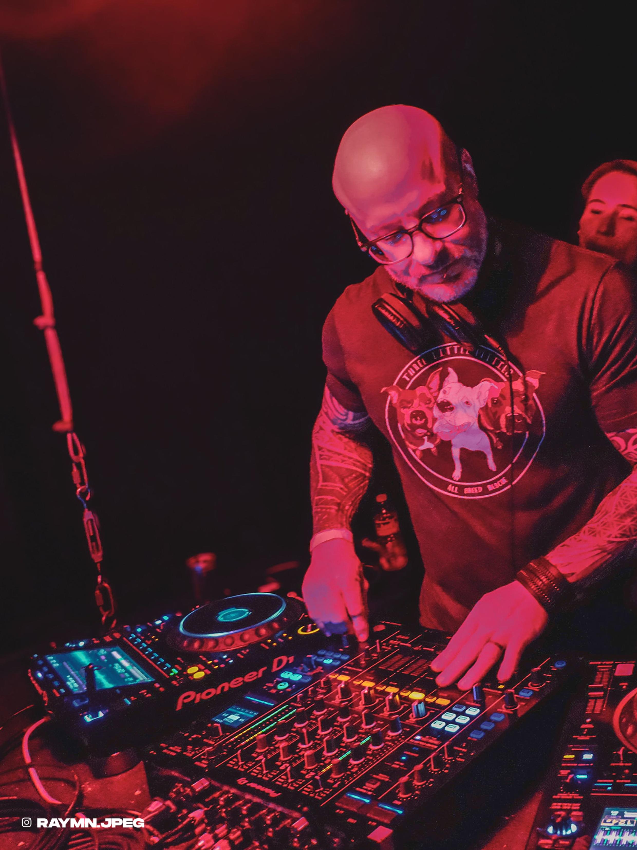Phil Anthony DJing at Flammable washed in glowing red light